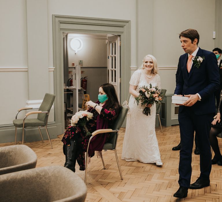 Bride & groom walk into registry office on wedding day 