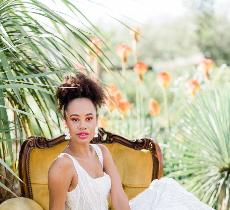 Bride in Forrest by Rachel Rose Bridal dress on yellow velvet yellow armchair in botanical garden