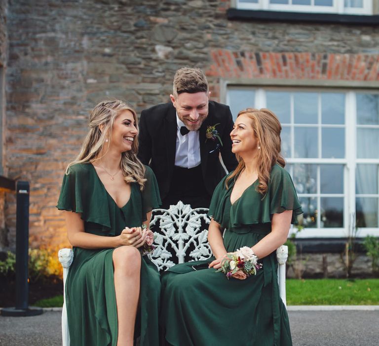 Groomsmaids in dark green dresses with frill collar and wrap skirt. 