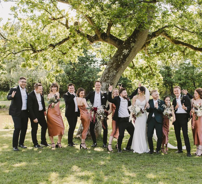 Bride & groom stand with their wedding party on the day of their wedding