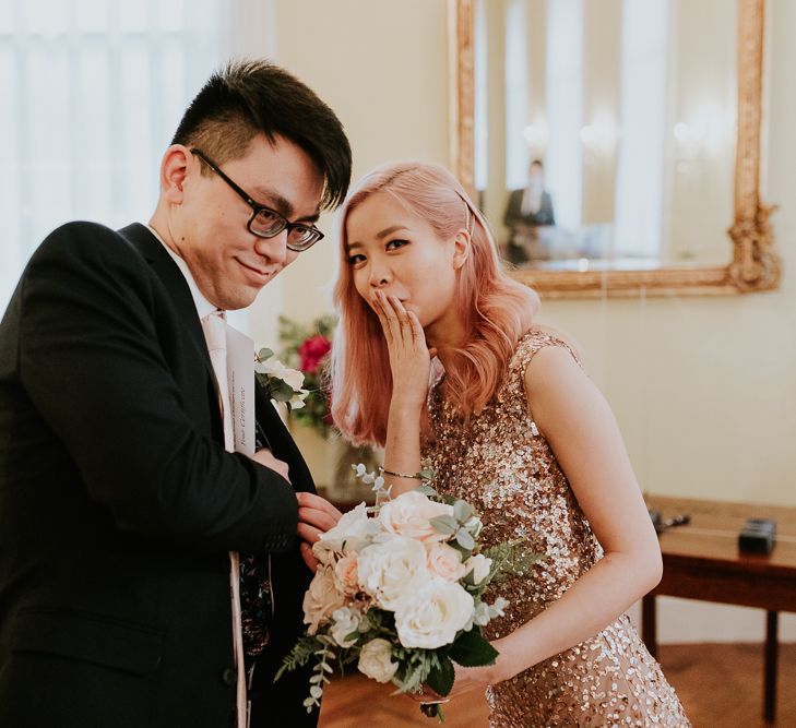 Groom putting the marriage certificate in his inside pocket 