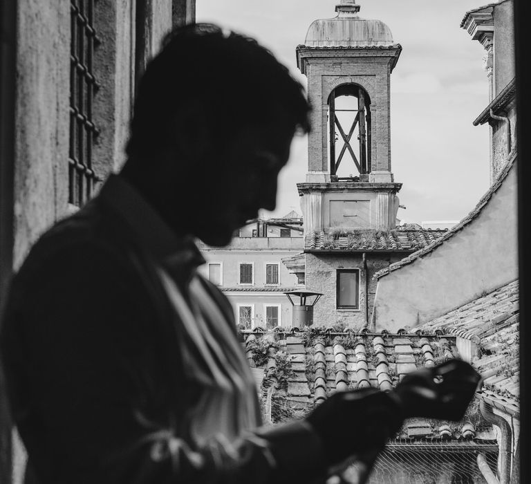 Silhouette of the groom getting ready for their 1960s themed Rome micro-wedding