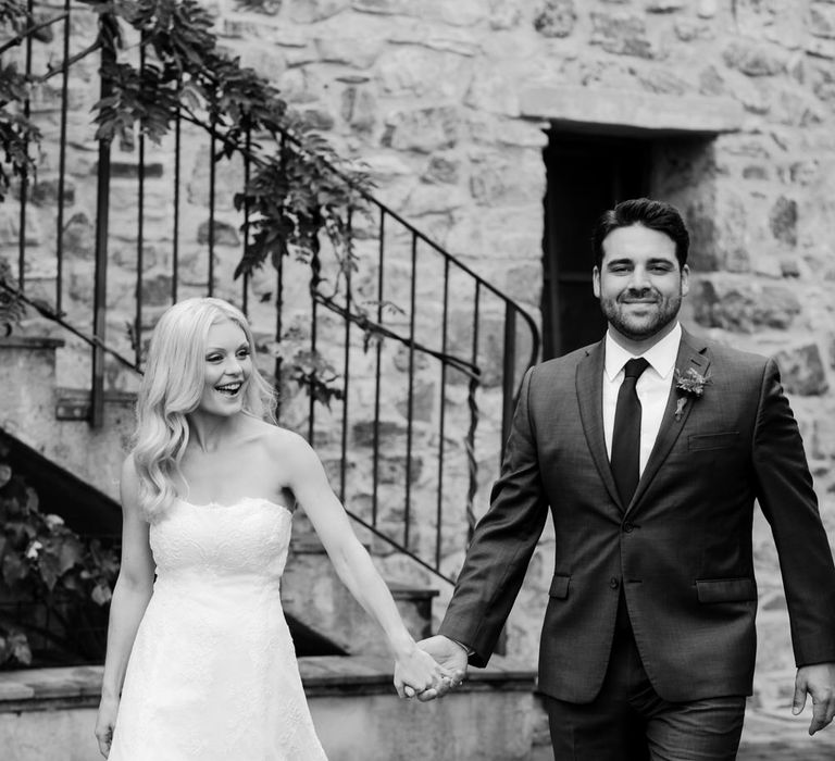 The bride and groom walking hand in hand through Podere Conti to their elopement ceremony