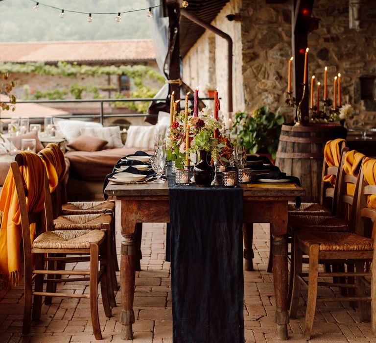 Intimate outdoor wedding dinner with earthy tones, navy linen details and pillar candles