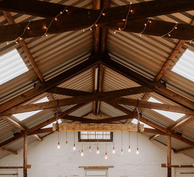 Tropical wedding theme at White Skye Barns with tropical plants and rattan chairs at the altar