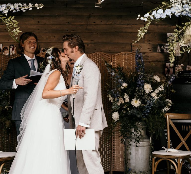 Bride & groom kiss during wedding ceremony 