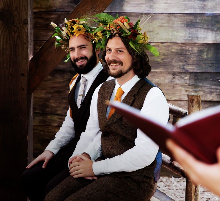 Grooms wear brown matching waistcoats and floral crowns