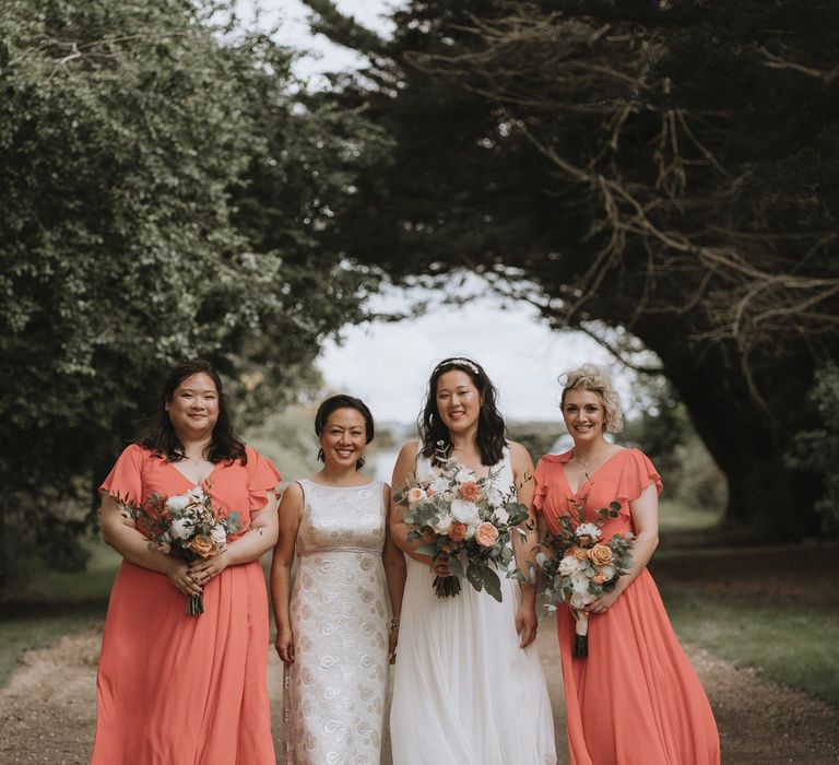 Bridal party portrait with the bride, mother of the bride and bridesmaids in peach dresses 