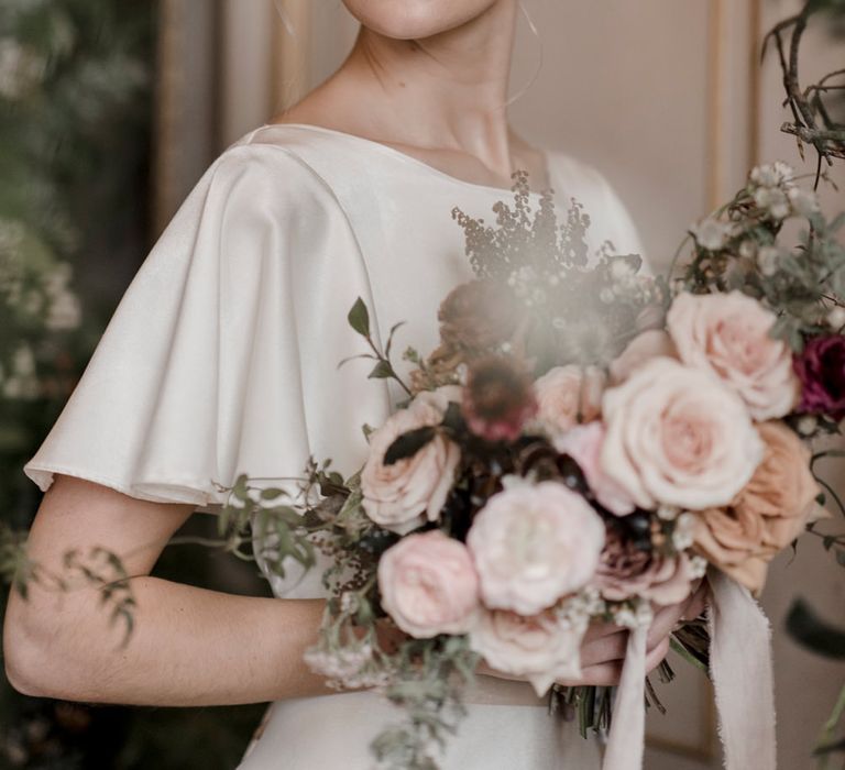 Blonde bride with pinned up bridal hair in a satin wedding dress with natural wedding makeup 