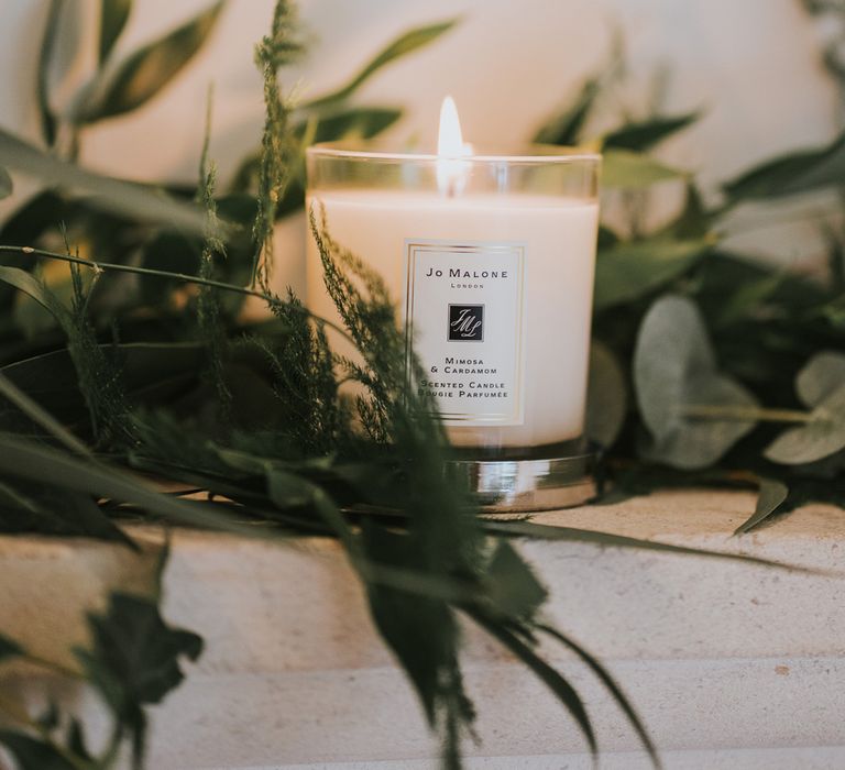 Jo Malone candle surrounded by greenery at Notley Abbey wedding