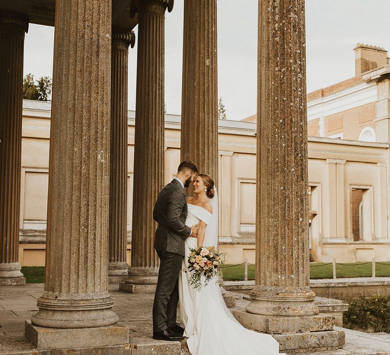 Groom places his hands on his brides waist as they look lovingly at one another