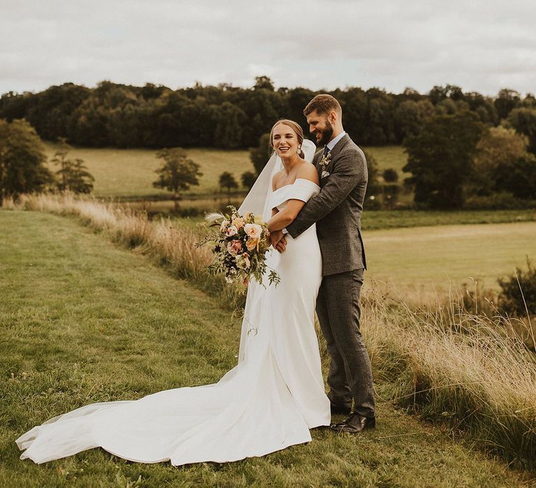 Groom wraps his arms around bride on their wedding day