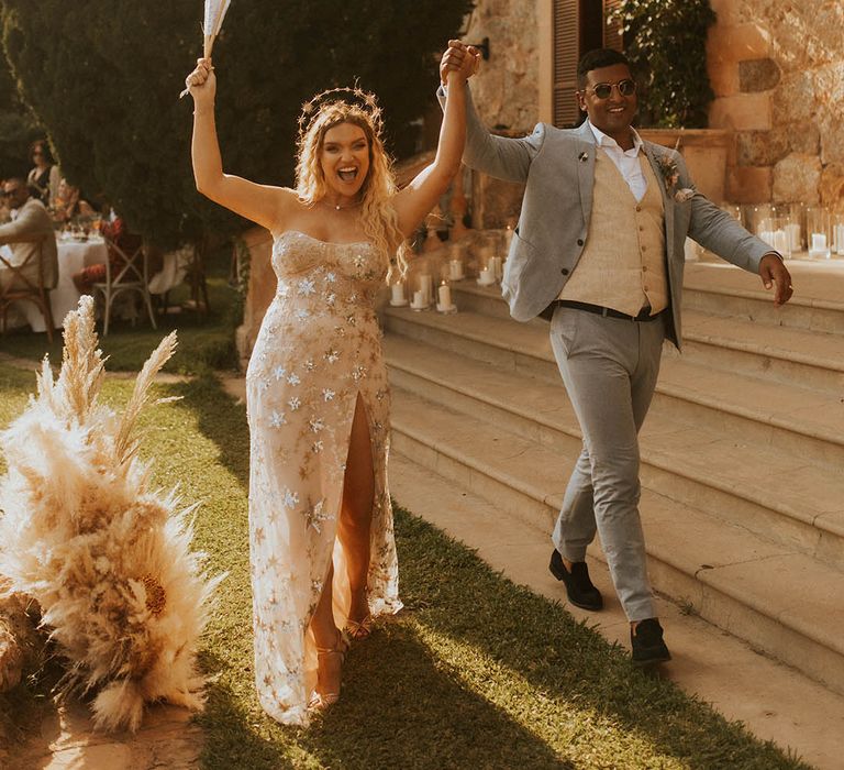 Bride & groom walk hand in hand with one another