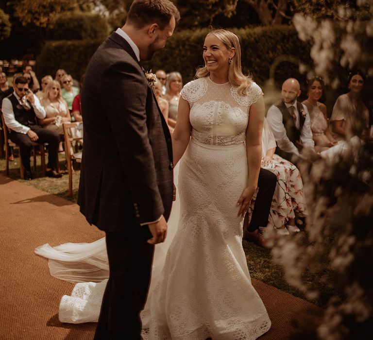 Outdoor Dewsall Court wedding ceremony with bride in a lace wedding dress