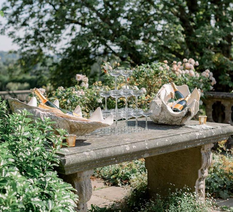 Champagne tower on stone table outdoors as the sun shines