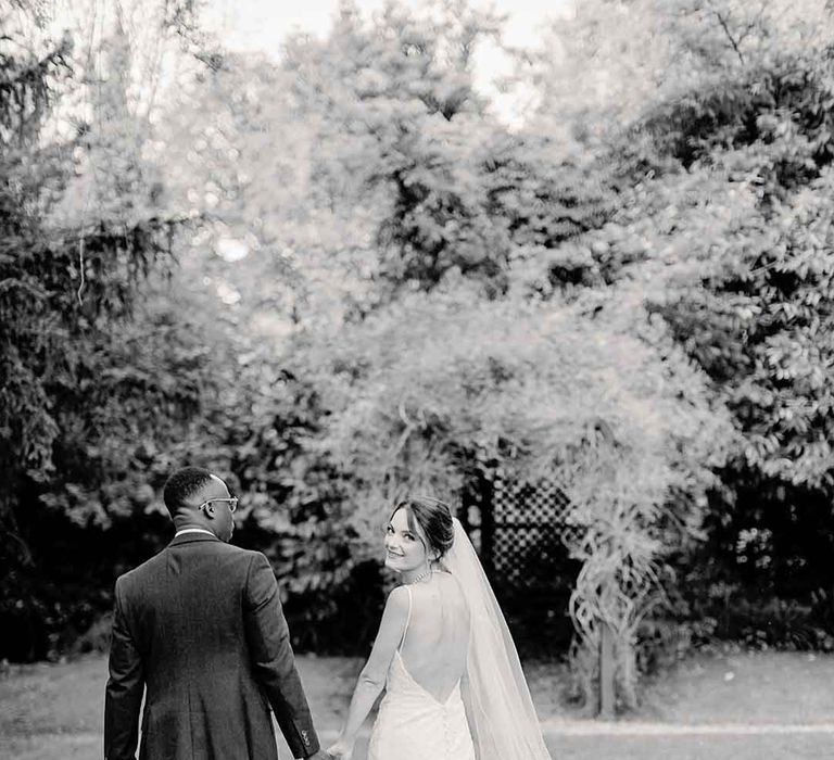 Bride & groom walk hand in hand on their wedding day