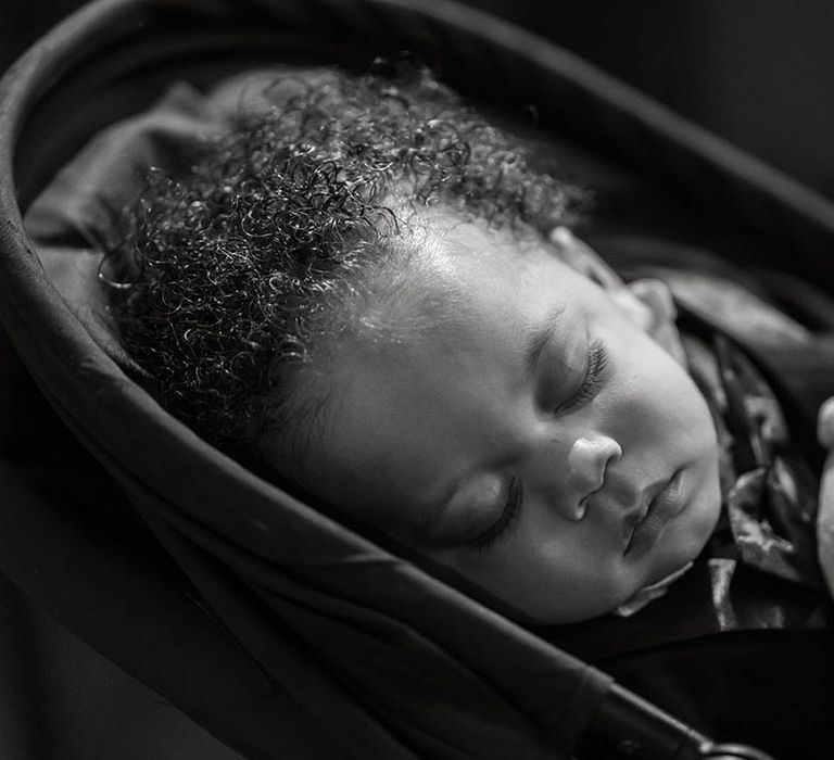 Black & white image of sleeping baby on wedding day