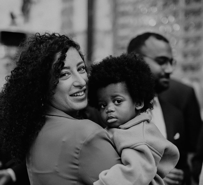 Wedding guests holds baby on wedding day