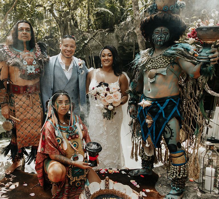 Bride and groom at traditional Mayan wedding in Mexico with floral displays and candles in lanterns for wedding decor