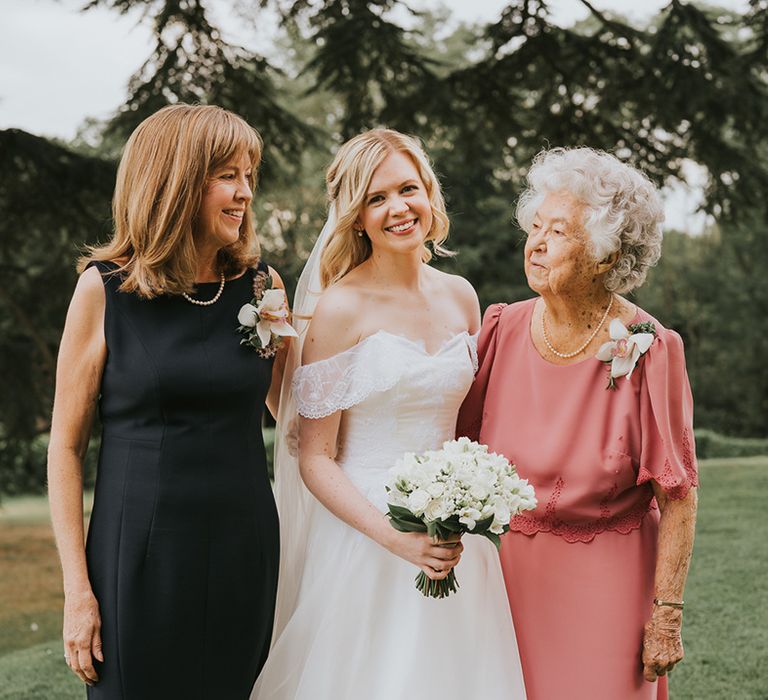 Bride with half up half down wedding hair in ballgown wedding dress with wedding guests 