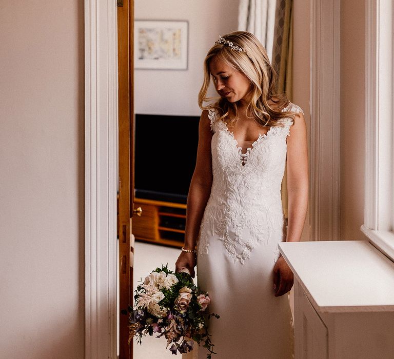 Bride in lace top wedding dress with train and pearl headpiece 