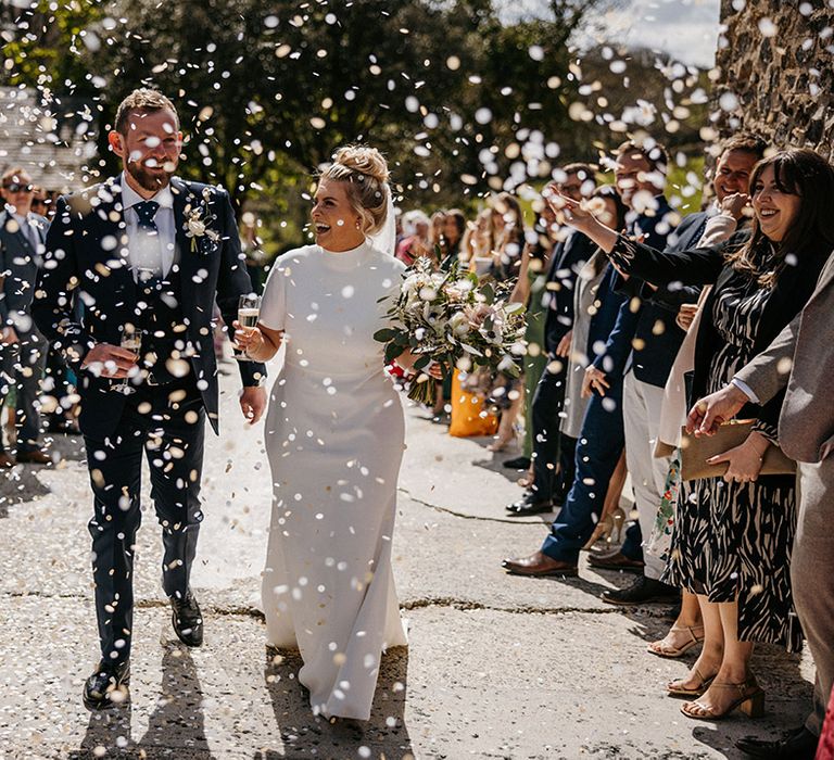 Bride and groom have white confetti exit from their wedding at Launcells Barton wedding venue 