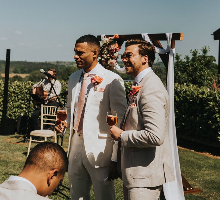 Groom and groomsmen sharing a cocktail before the wedding ceremony while they wait for the bride