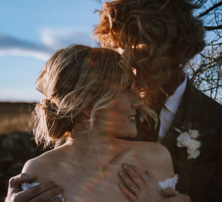 Close up of the bride and groom embracing on the day of their wedding 