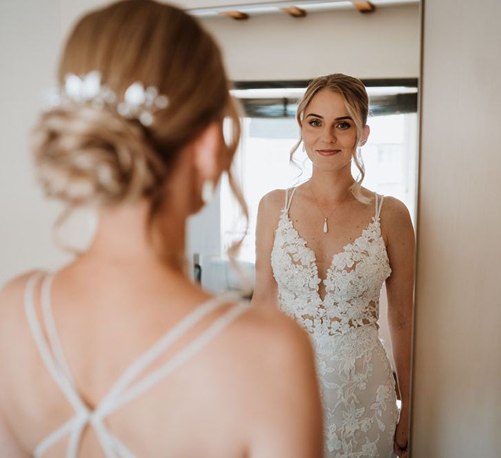 Bride wears lace wedding dress and blonde hair in chignon complete with pearl hair accessories 