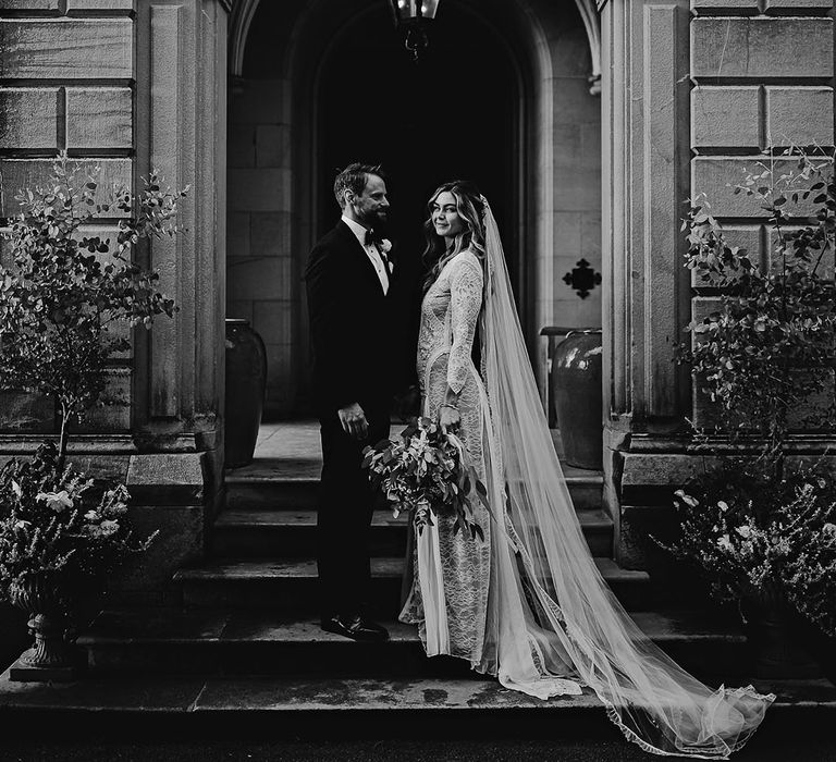 Bride and groom stand together at the entrance of Callow Hall wedding venue 