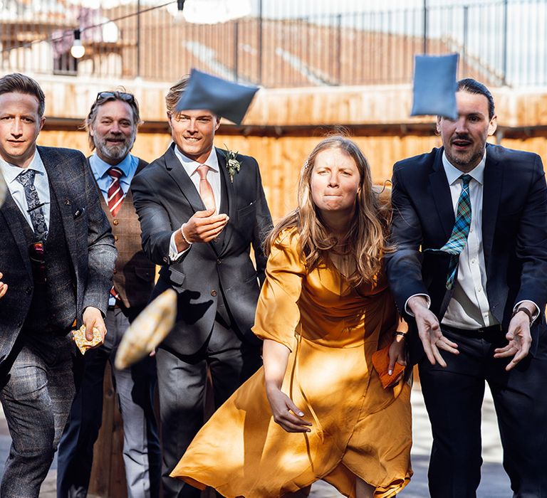 Wedding guests play games in the courtyard throwing beanbags 