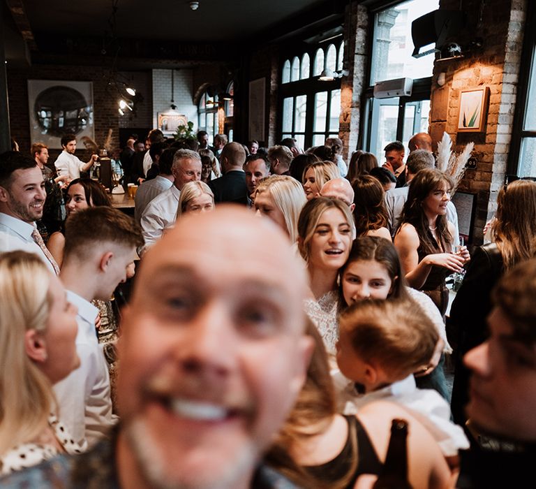 Wedding guests gather at pub during reception 