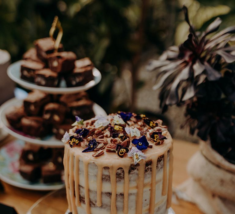 Naked cake with dry icing, flowers and walnuts