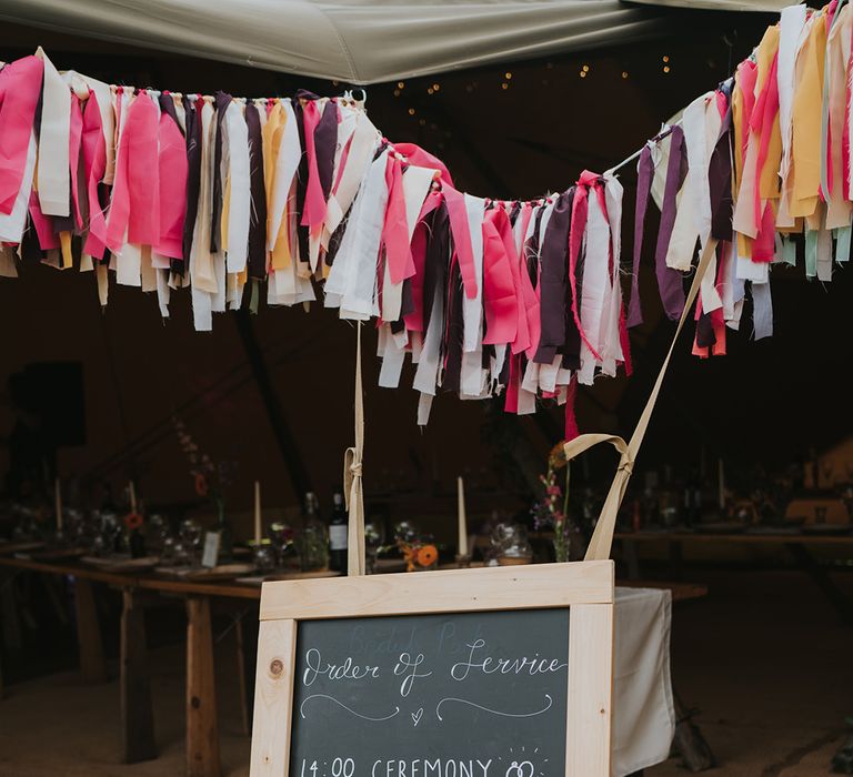 DIY chalkboard order of the day signage below colourful bunting 