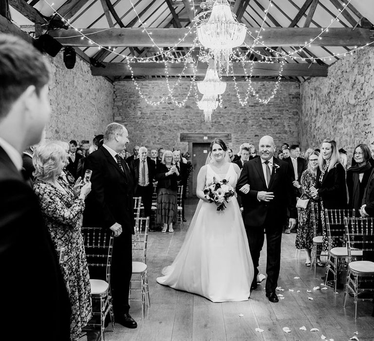 Father of the bride walking down the aisle with the bride at the rustic Notley Abbey wedding venue 