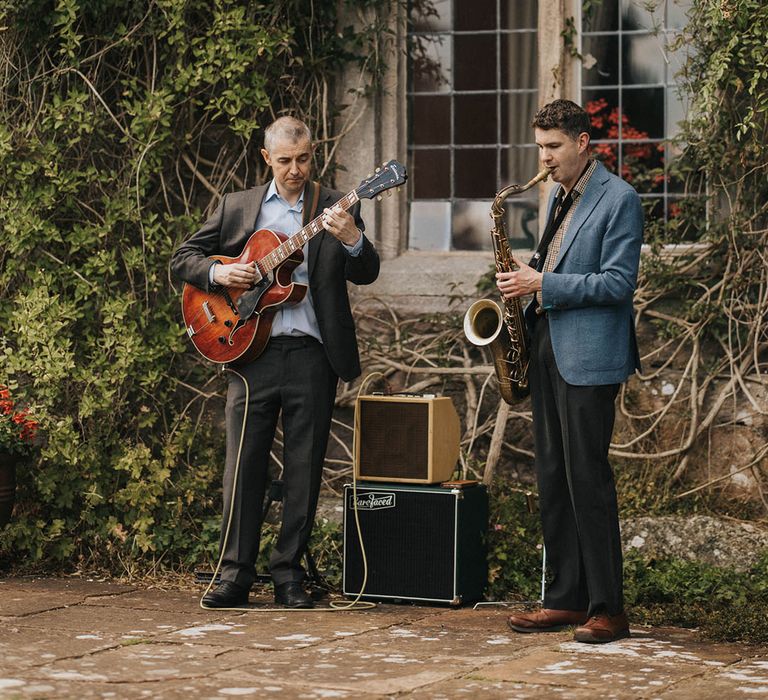 Jazz band duo playing outside for the wedding reception alongside the fun lawn games for summer garden party wedding 