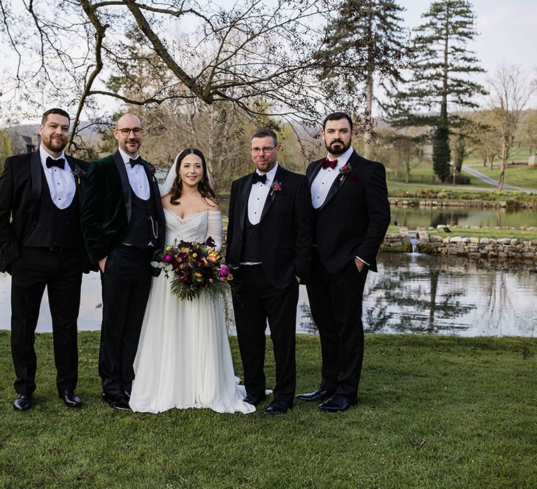 The groom and groomsmen all wear traditional and classic black tie and tuxedos for the wedding at Brinsop Court Manor House and Barn with the bride in a long sleeve wedding dress