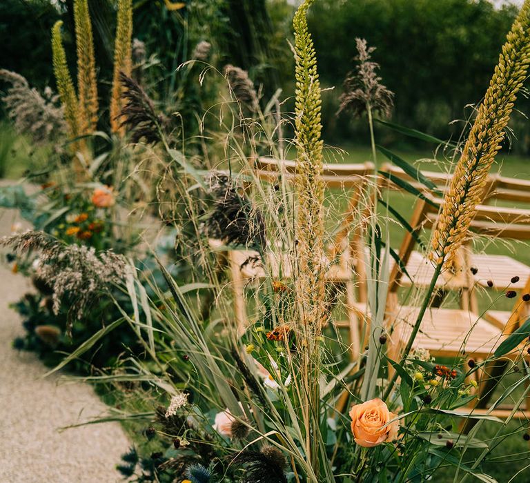 Extravagant botanical wedding aisle decor with roses and thistle for outdoor wedding ceremony 