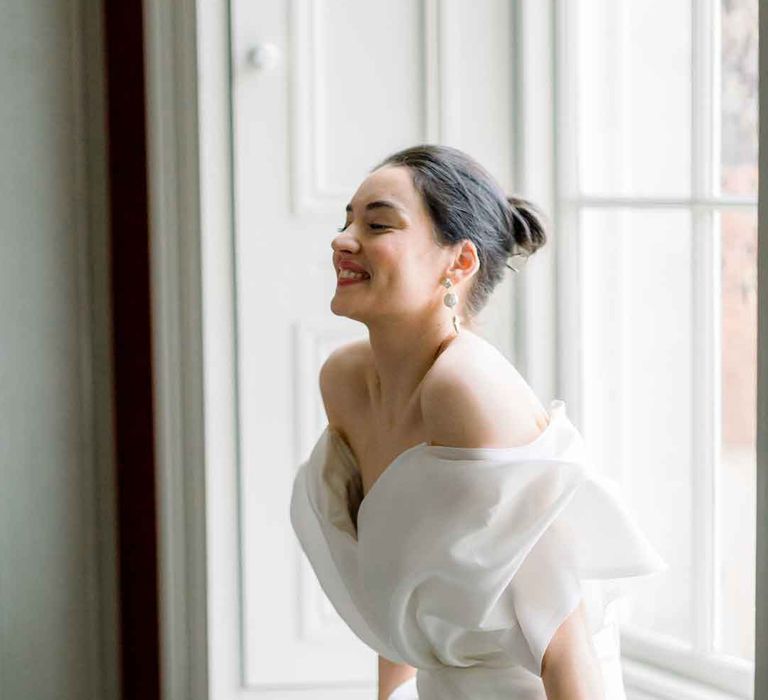 Bride wearing dramatic off the shoulder ivory wedding dress 