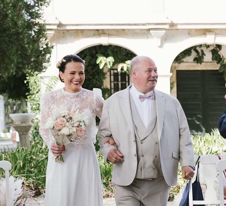 father of the bride in a beige suit walking his daughter down the aisle at Porto Vineyards in Portugal 