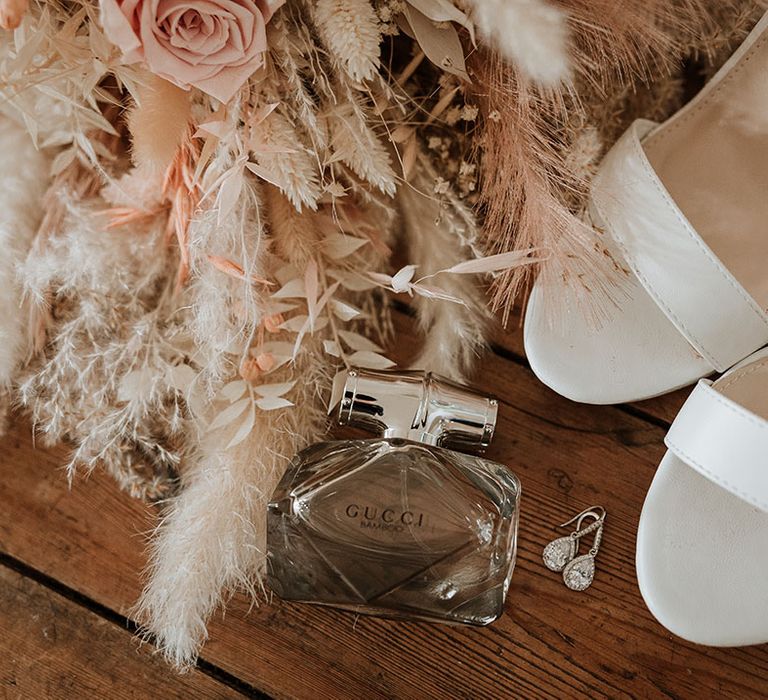 Gucci Bamboo wedding perfume with white open toe wedding shoes next to the dried wedding bouquet 