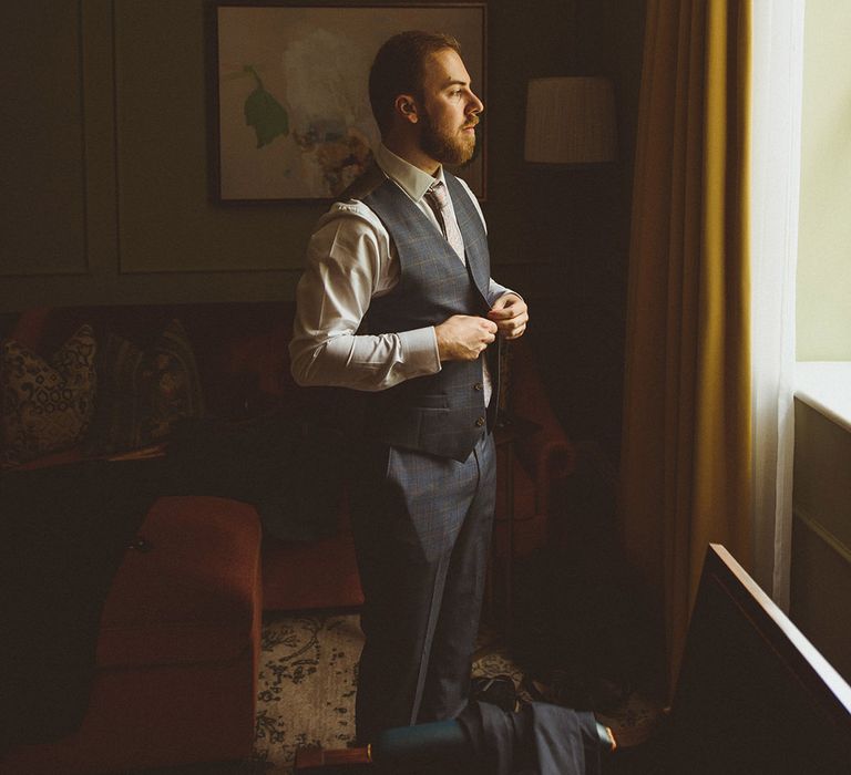 Groom wearing dark blue checkered suit with white shirt 