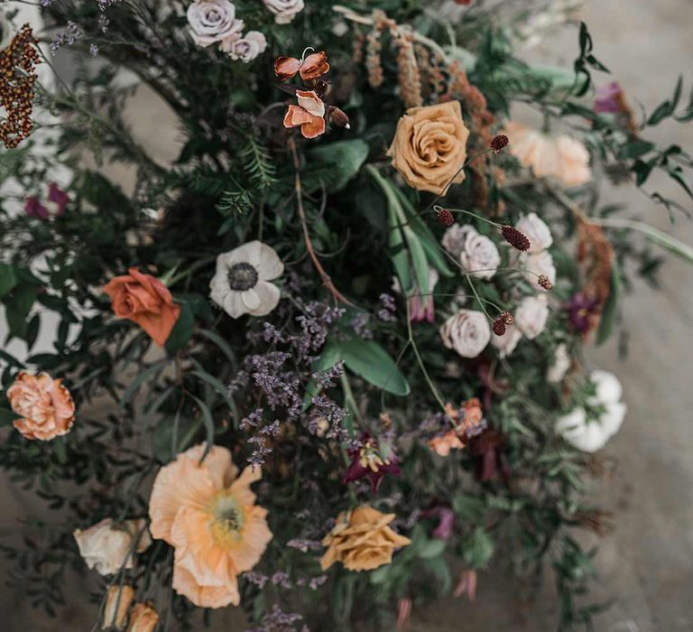 Dried wildflower wedding flower arrangements with roses, poppies and carnations at Buxted Park