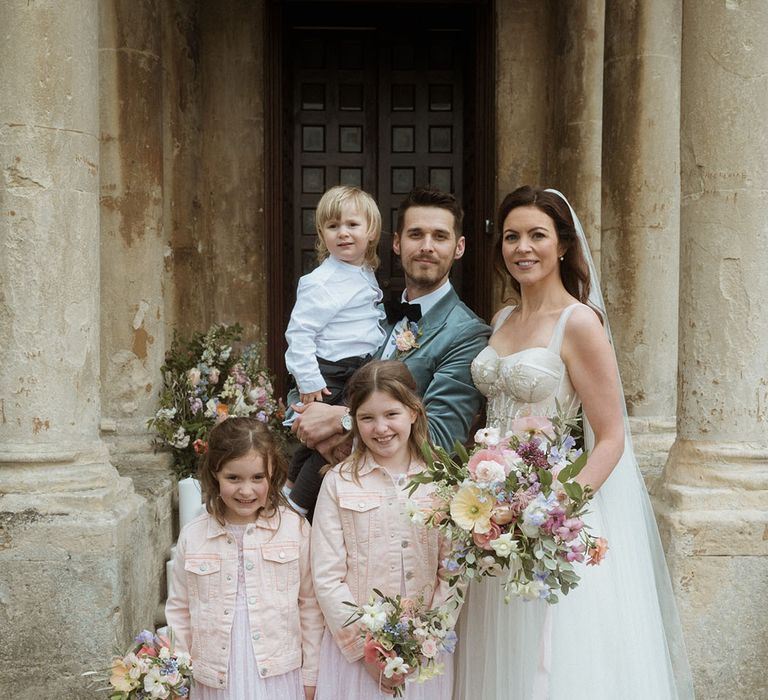 Family wedding photo of the bride and groom with their three children 