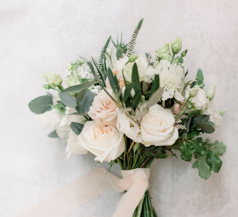 classic white and green wedding bouquet with roses and foliage tied with ribbon