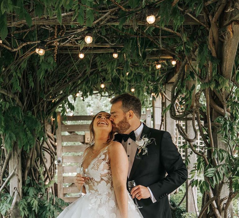 Groom kissing his brides cheek at The Tythe Barn Launton Wedding