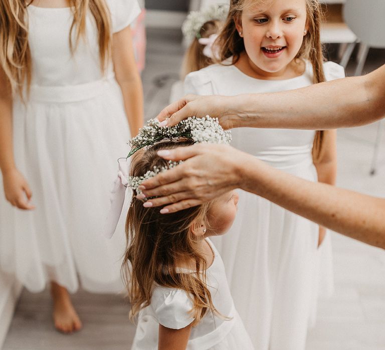 Flower girl in white dress with gypsophila flower crown 