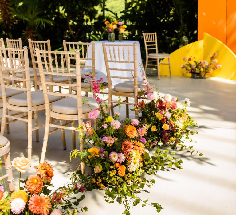 Glasshouse wedding venue with yellow wedding altar decoration with colourful wedding flowers 