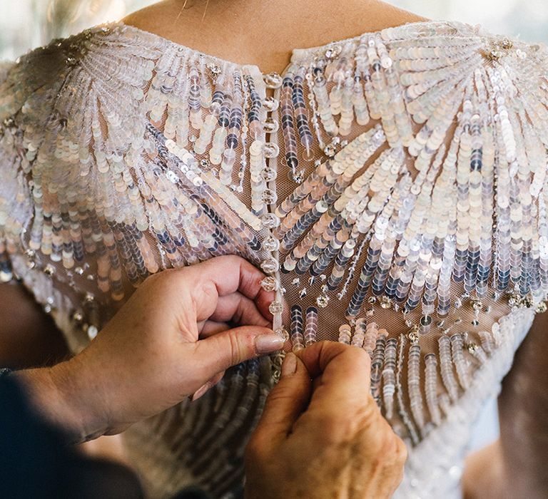 Bride gets zipped up into metallic sequin wedding dress 