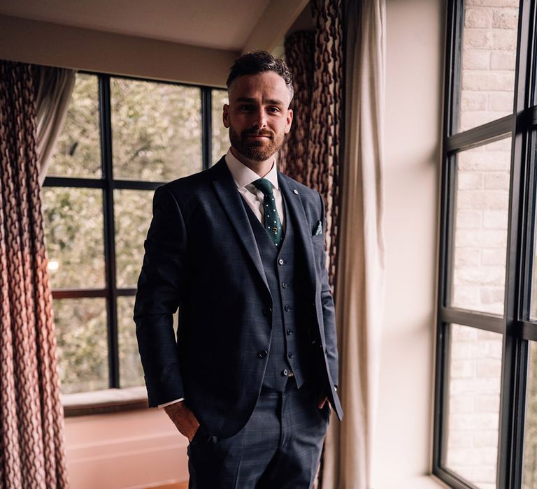 Groom in three piece navy wedding suit 